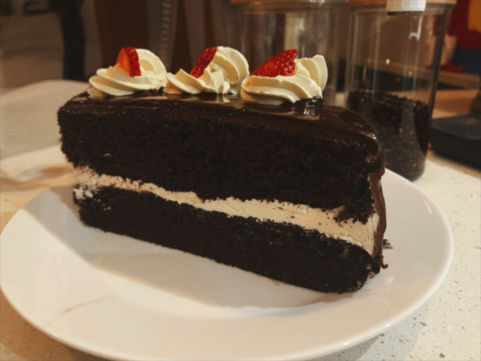 A chocolate layer cake with a pale filling and piped decoration