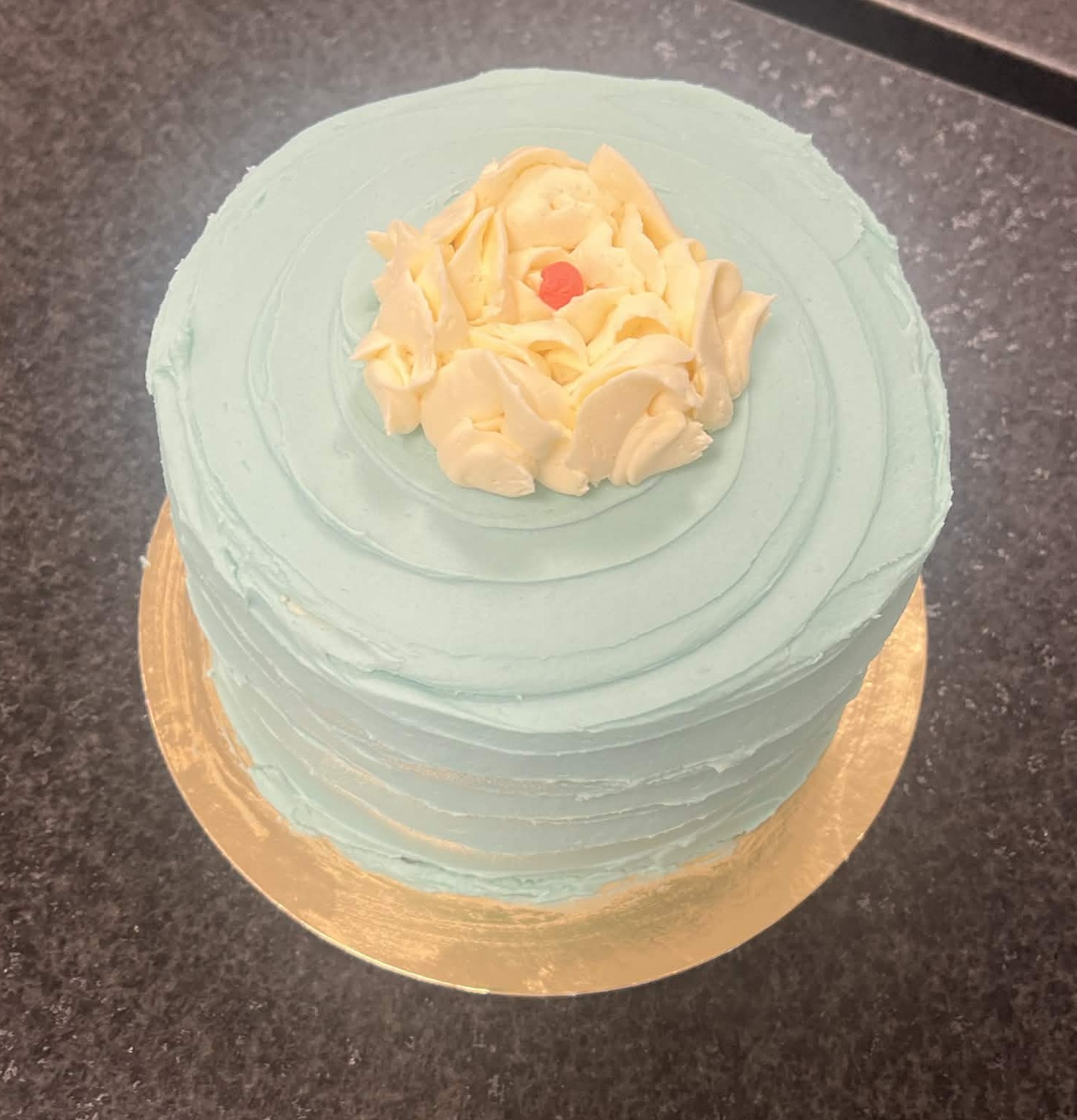 Pale blue sponge cake with a piped floral buttercream finish